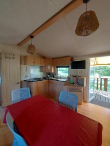 a kitchen with a red table and chairs in it at mobile home A15 in Boofzheim