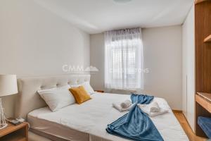 a white bed in a room with a window at Budva Old Town 3 bedroom Condo in Budva