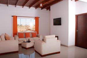 a living room with white furniture and a large window at Hotel Tierra Linda in San Ignacio de Velasco