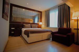 a bedroom with a bed and a chair and a window at Perada Suite & Room in Istanbul