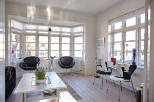a living room with black chairs and a table at Spacious House In Skagen in Skagen