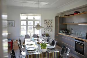 a kitchen with a table with chairs and a dining room at Spacious House In Skagen in Skagen