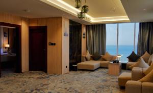 a hotel room with a living room with a view of the ocean at Mora by jodna - فندق مورا in Al Khobar
