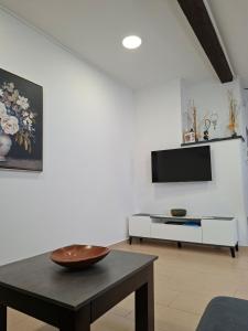 a living room with a table and a tv at Guest house Lavanda 4 in Njivice