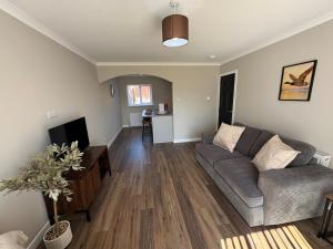 a living room with a couch and a tv at Ladysford Lets - The Duck in Peterhead