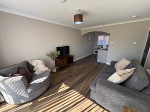 a living room with two couches and a television at Ladysford Lets - The Duck in Peterhead