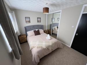 a bedroom with a bed with a cat sitting on it at Ladysford Lets - The Duck in Peterhead