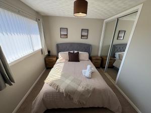 a bedroom with a bed with a teddy bear on it at Ladysford Lets - The Duck in Peterhead +9 photos
