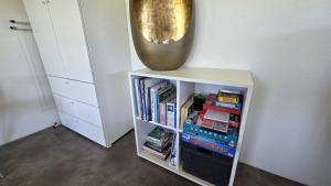 a book shelf with a gold vase on top of it at Sfeervol chalet midden in de natuur in Halle