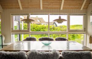 a dining room table with chairs in front of a window at Lovely Home In Saltum in Saltum