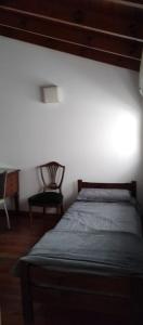 a bedroom with a bed and a chair in a room at Casa 51 La Plata in La Plata