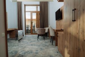 a living room with a table and chairs in a room at Kampoeng Indonesia Hotel in Khodzha-Ismail