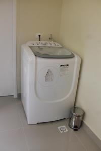 a white washing machine in a white room at O Melhor Chalé da Praia do Guaiúba, com Churrasqueira e Piscina Gigante in Guarujá
