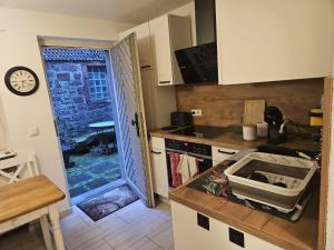a kitchen with a counter and a door open to a yard at Ferienhaus Rathausgasse in Büdingen +10 photos