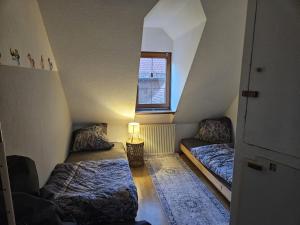 an attic room with two beds and a window at Ferienhaus Rathausgasse in Büdingen