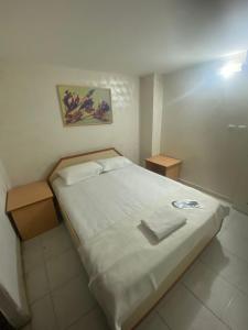 a bedroom with a large bed with two night stands at Karsu apart otel in Erdemli