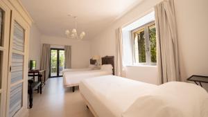 a white bedroom with two beds and a window at Hotel Villa Marcilla by Pandora Hoteles in Marcilla +60 photos