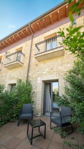 two chairs and a table in front of a building at Hotel Villa Marcilla by Pandora Hoteles in Marcilla