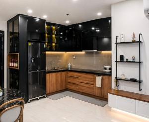 a kitchen with black cabinets and a stainless steel refrigerator at JiL JiL homestay in Trạm Chánh An +14 photos