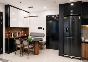 a kitchen with a table and chairs and a refrigerator at JiL JiL homestay in Trạm Chánh An