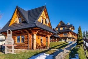 a log home with a black roof at Góralski Dom - Osada Gawlaki in Zakopane