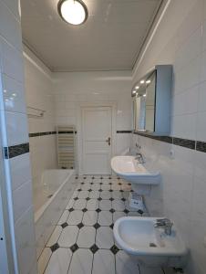 a bathroom with two sinks and a tub and a mirror at Haus Thulboden in Heiligenhafen