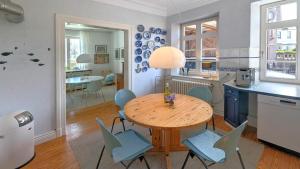 a kitchen and dining room with a wooden table and chairs at Haus Thulboden in Heiligenhafen +9 photos