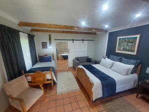 a bedroom with a bed and a chair and a couch at Ben Nevis Guest House in Clocolan