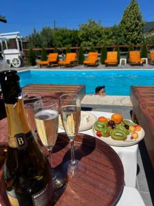 a bottle of champagne and two glasses on a table at Садиба Близнюки in Vorokhta