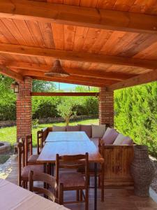 a wooden pergola with a table and chairs on a patio at Sandri Nature Lodge in Karahaxh