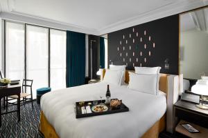 a hotel room with a large bed and a large window at Le Roch Hotel & Spa in Paris