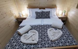 a bedroom with a bed with two towels on it at Drvena Oaza in Gornja Toplica