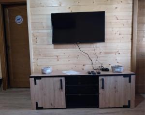 a flat screen tv on a wall with a desk at Drvena Oaza in Gornja Toplica