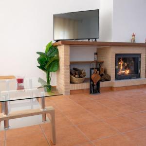 a living room with a fireplace with a television above it at Mi Rincón Blanco in Grazalema