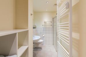 a bathroom with a toilet and a sink at Apartment AM MARKT Eisenach in Eisenach +14 photos