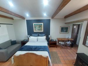 a bedroom with a bed and a couch and a table at Ben Nevis Guest House in Clocolan