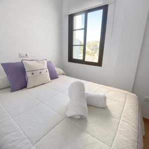 a bedroom with a large white bed with a window at Mi Rincón Blanco in Grazalema