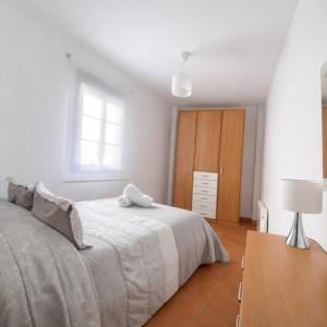a white bedroom with a bed and a table at Mi Rincón Blanco in Grazalema +7 photos