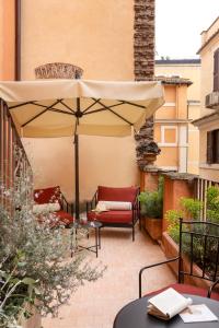 a patio with an umbrella and chairs and a table at Hotel Fori Imperiali in Rome