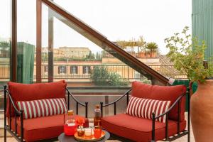 a balcony with two chairs and a table at Hotel Fori Imperiali in Rome