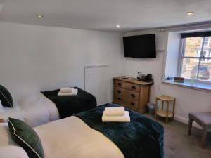 a hotel room with two beds and a television at The Downe Arms Inn in Castleton +22 photos