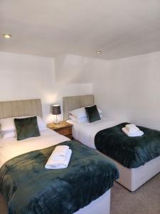 two beds sitting next to each other in a room at The Downe Arms Inn in Castleton