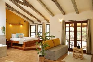 a bedroom with a bed and a couch in a room at בקתות נומה in Moshav Ramot