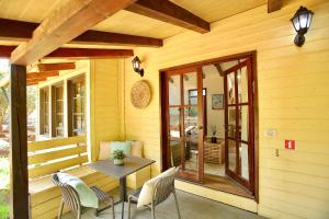 a wooden porch with a wooden table and chairs at בקתות נומה in Moshav Ramot