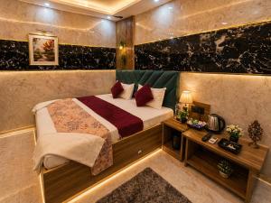 a bedroom with a bed and a table in a room at Hotel Jyoti Stay Inn 2 Min to Ram Tample in Ayodhya