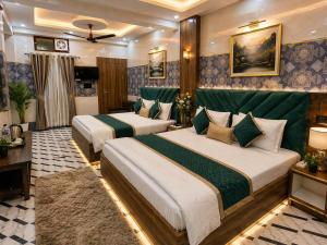 a hotel room with two beds in it at Hotel Jyoti Stay Inn 2 Min to Ram Tample in Ayodhya