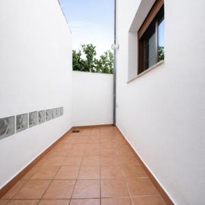 a hallway with white walls and a tile floor at Mi Rincón Blanco in Grazalema