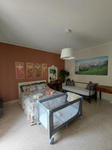a bedroom with a bed and a bench and paintings at B&B familiare Arcadia Polignano in Polignano a Mare