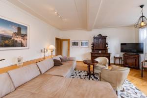 a living room with a couch and a tv at Apartment AM MARKT Eisenach in Eisenach