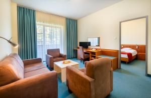 a hotel room with a couch and a bed at Hunguest Hotel Aqua Sol in Hajdúszoboszló